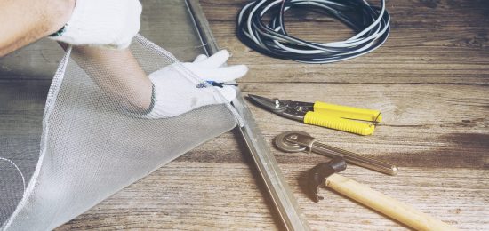 Man is working with mosquito wire screen installation
