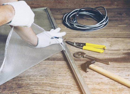 Man is working with mosquito wire screen installation
