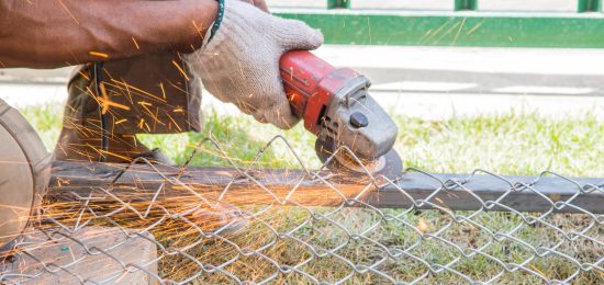 Worker cutting metal with grinder. Sparks while grinding iron