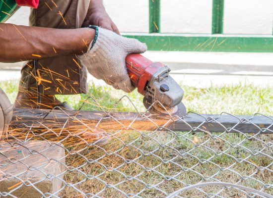 Worker cutting metal with grinder. Sparks while grinding iron